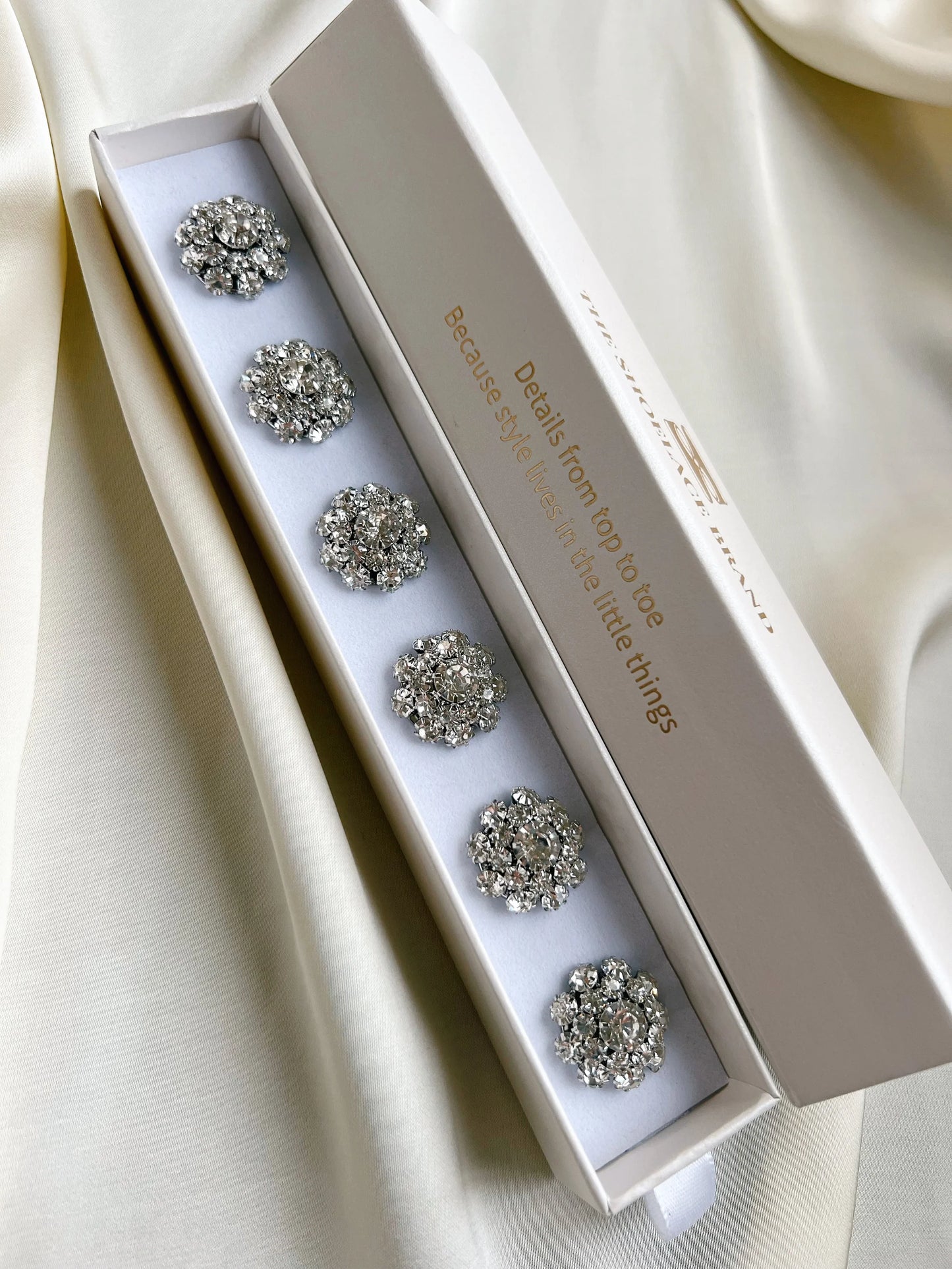 Olivia – Kristallblomma Knappberlock Silver